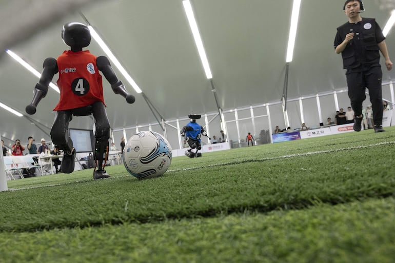 Un robot humanoide patea el balón durante un partido de fútbol, en una presentación para medios de comunicación previa a los Juegos Mundiales de Robótica Humanoide 2026, en Pekín, China, el 14 de agosto de 2026.