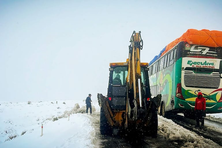 Fotografía cedida por el Ministerio de Obras Públicas de Bolivia que muestra operarios trabajando con maquinaria amarilla para limpiar una carretera durante una nevada la semana pasada en La Paz (Bolivia). 