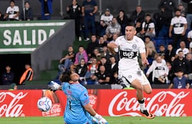 Bernardo Romeo de Olimpia intenta esquivar al portero de Barracas Central durante la Copa Sudamericana en el Estadio Defensores del Chaco.