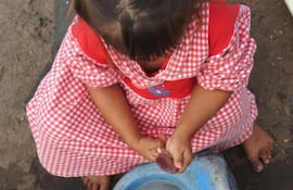Niña realizando trabajos domésticos.