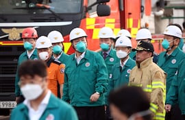 El presidente surcoreano, Yoon Suk Yeol (2 de la izquierda), está acompañado por otros funcionarios mientras inspecciona el lugar de un incendio en una fábrica primaria de baterías de litio en Hwaseong, a 45 kilómetros al sur de Seúl, 24 de junio de 2024.