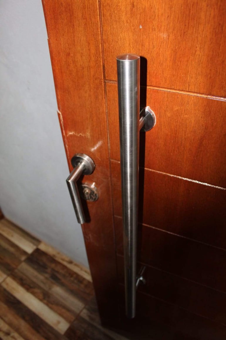 Puerta de madera moderna con tirador de acero, en ambiente interior cálido y sin personas visibles.