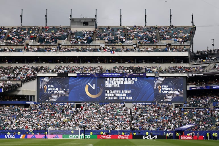 Los asistentes regresan a las gradas mientras una pantalla electrónica muestra un mensaje sobre la suspensión del encuentro durante el partido de la fase de grupos de la Copa Mundial de la FIFA 2026 entre Francia e Irak, en Filadelfia, Pensilvania, EE. UU.