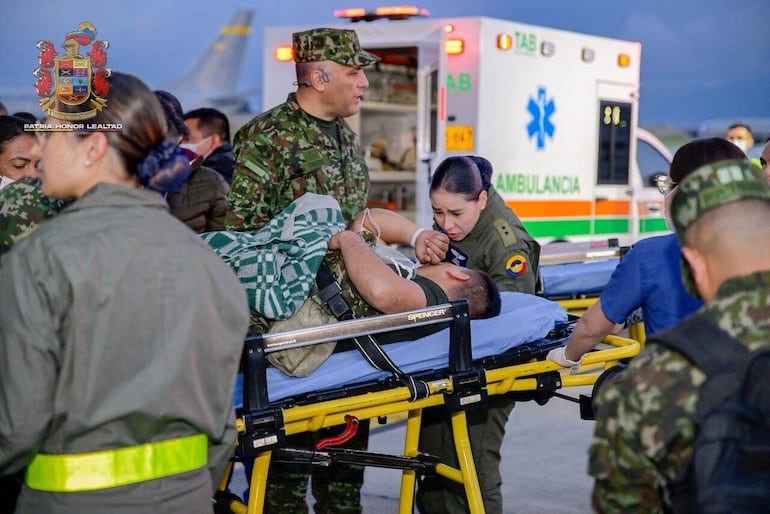 Fotografía cedida por las Fuerzas Militares de Colombia (FFMM) que muestra a integrantes de organismos de rescate y del Ejército de Colombia trasladando a un herido de un accidente aéreo este lunes, en el Comando Aéreo de Transporte Militar (CATAM) en Bogotá (Colombia).  EFE