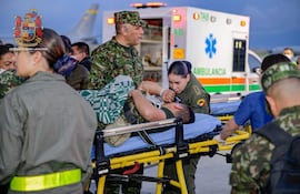 Fotografía cedida por las Fuerzas Militares de Colombia (FFMM) que muestra a integrantes de organismos de rescate y del Ejército de Colombia trasladando a un herido de un accidente aéreo este lunes, en el Comando Aéreo de Transporte Militar (CATAM) en Bogotá (Colombia).