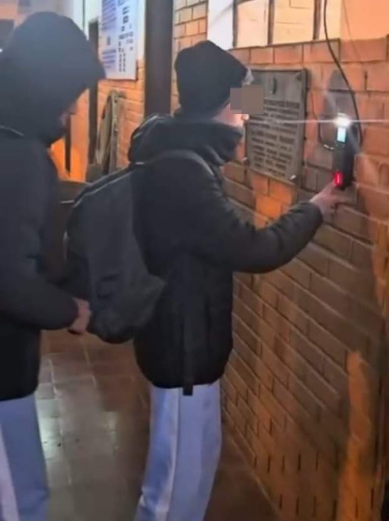 Un estudiante acerca su dedo a un reloj biométrico para registrar su ingreso en un edificio educativo en Caazapá.