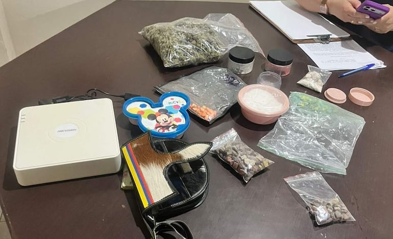 Mesa con recipientes, bolsas de sustancias e instrumentos de escritura. Sin personas visibles en la imagen.