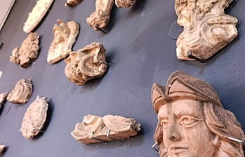 Esculturas de relieve de terracota expuestas en una pared oscura en el museo, sin personas visibles.