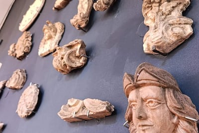 Esculturas de relieve de terracota expuestas en una pared oscura en el museo, sin personas visibles.