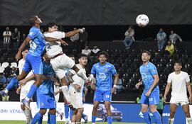 El defensor de Libertad, Robert Rojas se impone en las alturas sobre el uruguayo Lucas Morales. De frente observan la acción Matías Espinoza, Adrián Alcaraz, Manuel Capasso y Lorenzo Melgarejo.