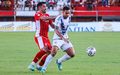 El volante de General Caballero JLM, Guillermo Hauché, intenta cortar el avance del lateral de Ameliano Abel Paredes. Un duelo repetido en la primera parte.
