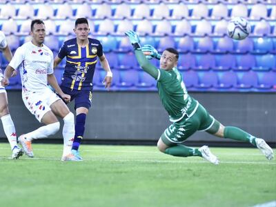 Alex Álvarez (c), futbolista de Sportivo Trinidense, define a gol en un partido ante Nacional por el fútbol paraguayo en el estadio Defensores del Chaco, en Asunción.