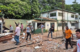 Empleados de la agroexportadora Algisa de Coronel Bogado en el sector destruido por las explosiones provocadas por los delincuentes durante el asalto.