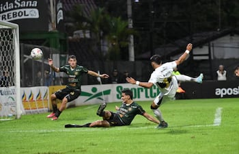 El central Javier Vallejos (22 años) de Rubio Ñu se arroja y desvía un claro remate a gol de Rodney Redes (26) esta tarde en La Arboleda.
