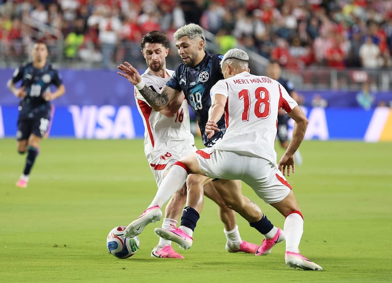 Julio Enciso de Paraguay disputa el balón contra Ismail Yüksek y Mert Müldür de Turquía durante el partido del Grupo D de la Copa Mundial de la FIFA 2026 entre Turquía y Paraguay en el San Francisco Bay Area Stadium.