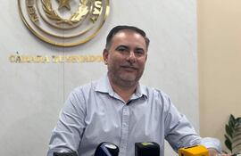 Éver Villalba sentado frente a un micrófono en la Cámara de Senadores, con camisa de cuadros y expresión amigable.