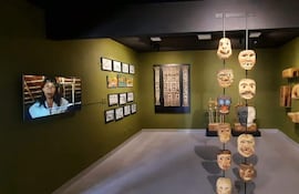 Sala verde con objetos de arte indígena y pantalla mostrando a mujer indígena, resaltando la cultura paraguaya.