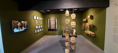 Sala verde con objetos de arte indígena y pantalla mostrando a mujer indígena, resaltando la cultura paraguaya.