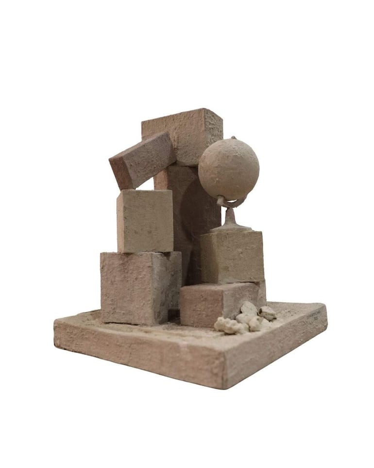 Escultura abstracta en tonalidad beige compuesta por bloques rectangulares y un globo esférico en un fondo blanco.