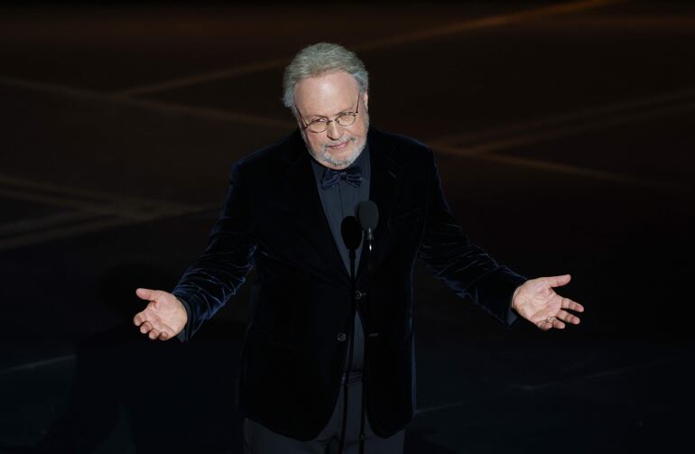 Billy Crystal rinde homenaje a Rob Reiner y a su esposa Michele en el escenario durante la 98.ª ceremonia anual de los Premios Óscar.