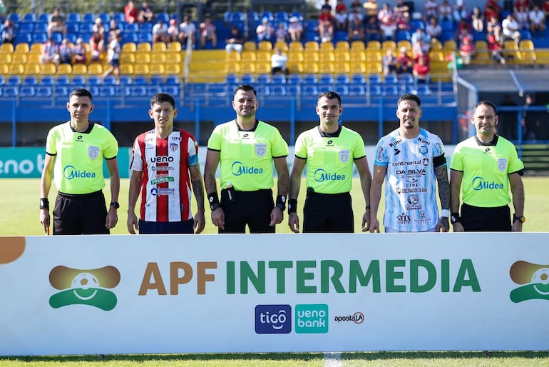 Los capitanes de ambos equipos posan con la terna arbitral que estuvo en cancha.