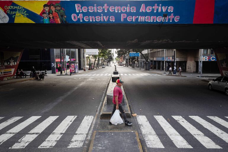 Una persona camina por un calle vacía este domingo, en Caracas, Venezuela.