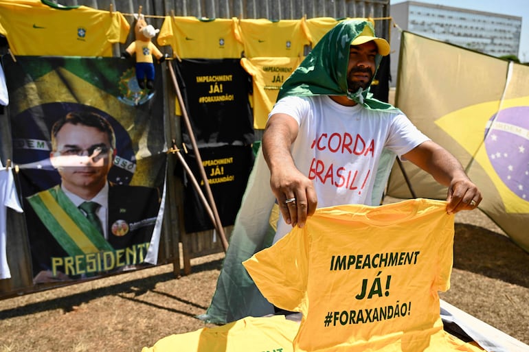 Un hombre vende merchandising de campaña en apoyo al candidato presidencial Flavio Bolsonaro frente al Congreso Nacional en Brasilia, durante una audiencia en el Tribunal Supremo Federal (STF) de Brasil.