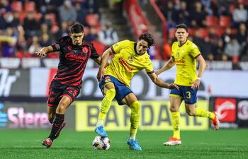 MEX5660. TIJUANA (MÉXICO), 21/11/2024.- Iván Tona (i) de Tijuana disputa un balón con Alan Cervantes de América este jueves, durante a un partido de reclasificación del torneo Apertura 2024 de la Liga del fútbol mexicano entre Tijuana y América, en el estadio Caliente, en Tijuana, estado de Baja California (México). EFE/ Alejandro Zepeda