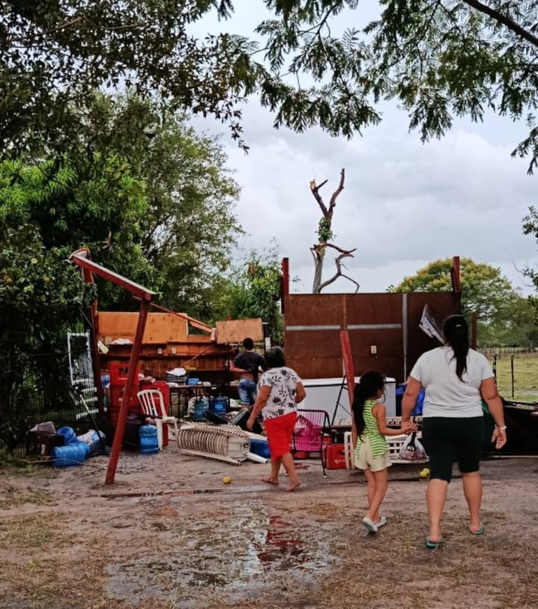 Los integrantes de una de las familias afectadas por el temporal observan con impotencia su vivienda de madera, con techo de zinc, que quedó destruida tras la tormenta.