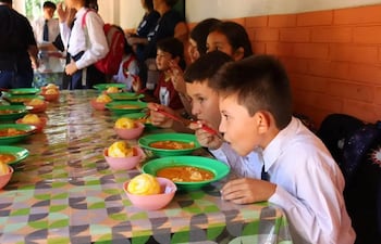 Niños comiendo en la escuela Teniente José María Fariña de Caacupé.