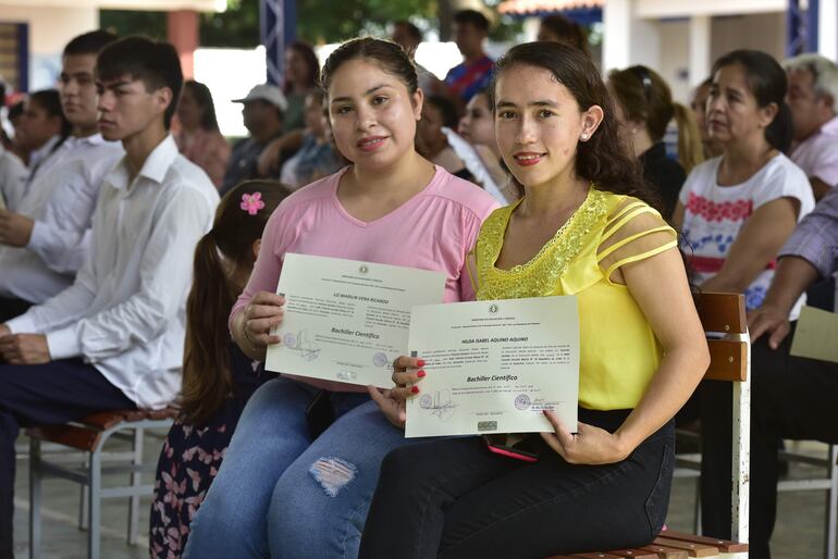 Liz (derecha) y su compañera Hilda muestran con orgullos sus cartones de egresadas del bachiller de educación para adultos en la escuela República de Cuba de Asunción.