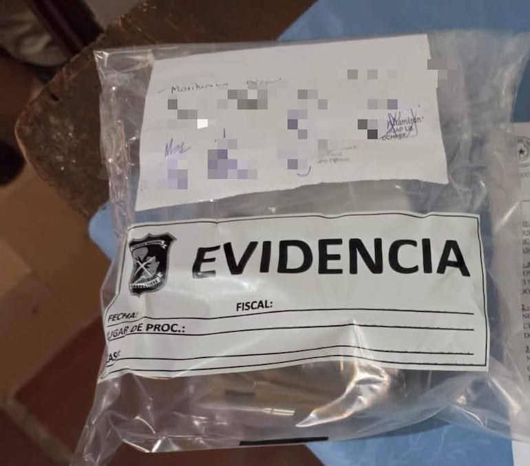 Bolsa transparente etiquetada con 'EVIDENCIA' conteniendo objetos no identificables en un ambiente judicial.