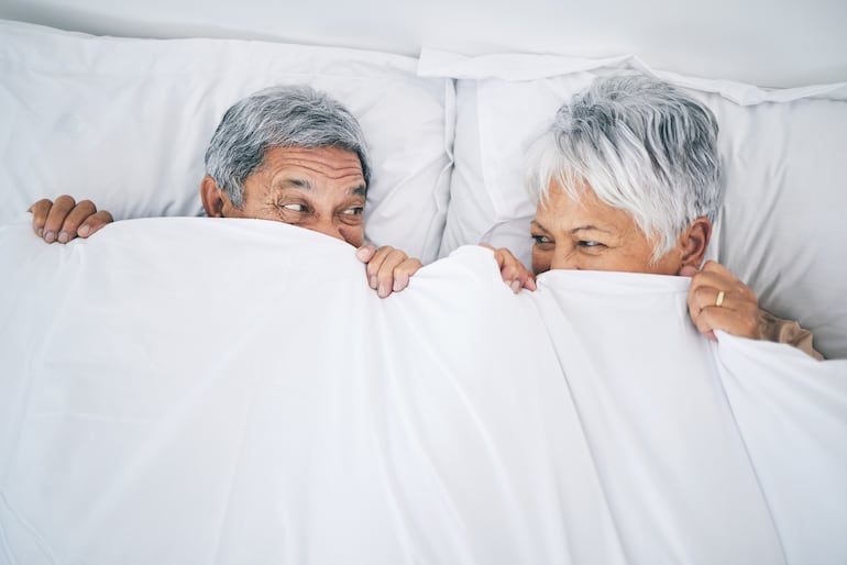 Pareja de adultos mayores en la cama.