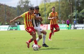 El extremo aurirrojo Derlys Cabañas intenta desbordar ante la marca del capitán albinegro Alfredo Cabrera. (Foto: Martín Ledesma)