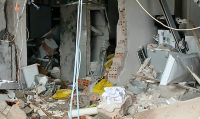 Espacio interior desordenado con escombros, materiales de construcción y objetos como un bote de basura blanco y una bolsa amarilla.