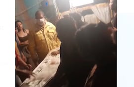 Momento en el que un bombero inspeccionaba el cuerpo de la mujer y luego los familiares determinaran llevarla de urgencia al hospital, con féretro incluido.