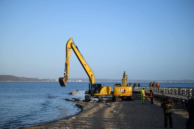 Se observan excavadoras en la playa de Niendorf, al norte de Alemania, el 27 de marzo de 2026, cerca del lugar donde una ballena jorobada había quedado varada en aguas poco profundas de la costa del mar Báltico, antes de que el animal aparentemente se liberara durante la noche tras una operación de rescate a gran escala.