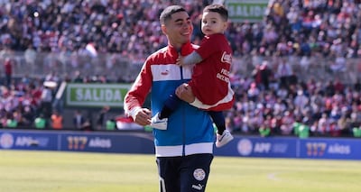 Miguel Almirón ingresando al campo de juego del Defensores del Chaco con Francesco en sus brazos. Fue un Día del Padre muy especial para el futbolista internacional.