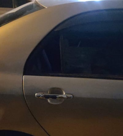 Puerta de vehículo plateado en vía pública, sin personas visibles ni elementos identificables en el entorno.