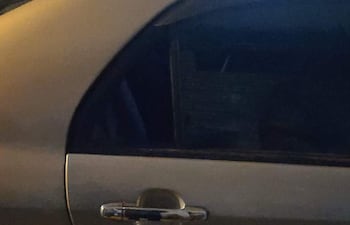 Puerta de vehículo plateado en vía pública, sin personas visibles ni elementos identificables en el entorno.