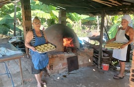 Doña Tomasa y Francisca Dávalo, monstrando el resultado de sus chipas cocinadas en el tradicional tatakua.