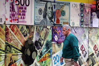 Un hombre pasa junto a una imagen a gran escala de un billete de dólar estadounidense en una oficina de cambio de divisas en El Cairo, Egipto.