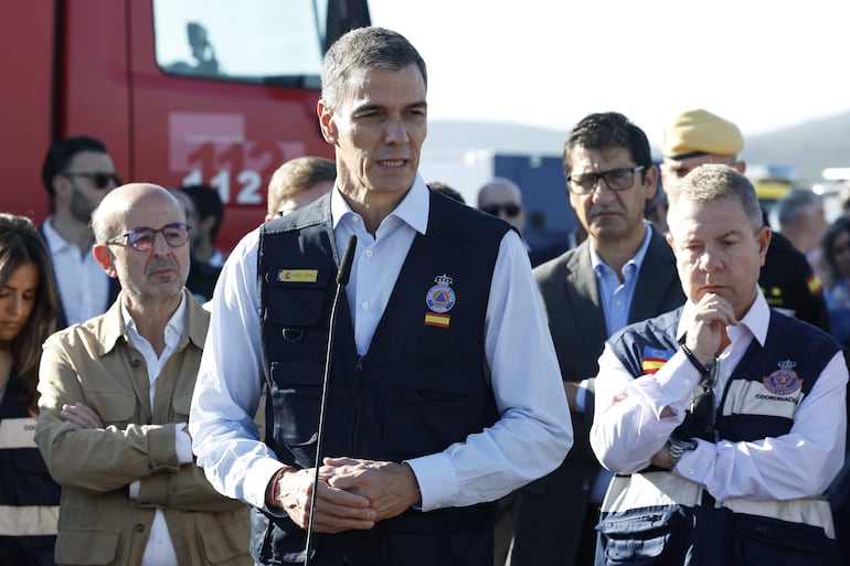 El presidente del Gobierno, Pedro Sánchez (c), junto al presidente de Castilla-La Mancha, Emiliano García-Page (d), realizan declaraciones a los medios durante su visita al lugar del accidente de dos trenes de alta velocidad, uno de Renfe y otro de Iryo, que han colisionado a primera hora de este miércoles a la altura de la estación de Urda (Toledo).