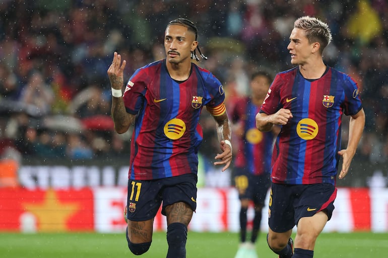 El delantero brasileño del Barcelona, Raphinha, lo celebra tras marcar el quinto gol de su equipo y un triplete durante el partido de fútbol de la liga española entre el FC Barcelona y el Racing Santander en el estadio Camp Nou.