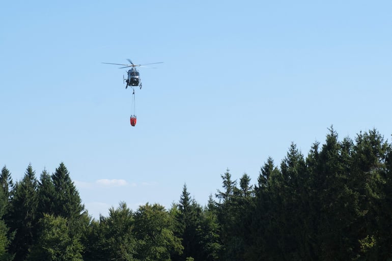 Un helicóptero McDonnell Douglas MD-902 Explorer de la policía belga se prepara para arrojar agua sobre un incendio forestal en la reserva natural de Hautes Fagnes (High Fens) en Jalhay, al este de Bélgica, el 14 de agosto de 2026. (Photo by NICOLAS LAMBERT / Belga / AFP) / Belgium OUT