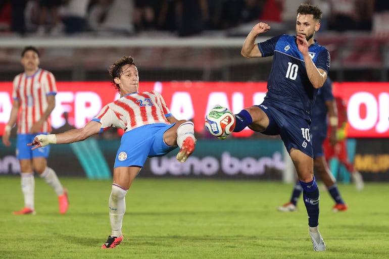 Matías Galarza (i) de Paraguay disputa un balón con Jacob Montes de Nicaragua este viernes, en un partido amistoso entre Paraguay y Nicaragua previo a la Copa Mundial de Fútbol 2026 en el estadio Defensores del Chaco en Asunción.
