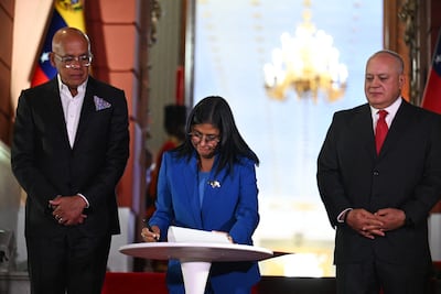 La presidenta Delcy Rodriguez (C) promulga la histórica ley de aministía para presos políticos en Venezuela. La acompañan el presidente del Parlamento y su hermano, Jorge Rodríguez (i) y ministro del Interior, Diosdado Cabello.