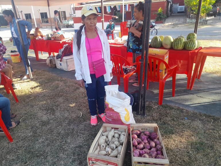 Una productora ofrece sus productos en la feria en la plaza de la comunidad.