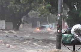 Vehículo atrapado por raudales sobre la calle Yuasy'y, barrio Terminal de Asunción. En el barrio, el exintendente Óscar "Nenecho" Rodríguez (ANR-HC) había prometido obras de desagüe pluvial que jamás cumplió.