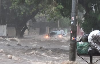 Vehículo atrapado por raudales sobre la calle Yuasy'y, barrio Terminal de Asunción. En el barrio, el exintendente Óscar "Nenecho" Rodríguez (ANR-HC) había prometido obras de desagüe pluvial que jamás cumplió.